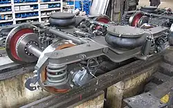 Zwei Luft­fe­dern auf Drehgestellrahmen zur Sekun­där­fe­de­rung gegen den auslenkbaren Wagenkasten