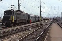 Ae 4/7 mit einem Mitteleinstiegs- und einem Leichtstahlwagen in Romans­horn, 1988