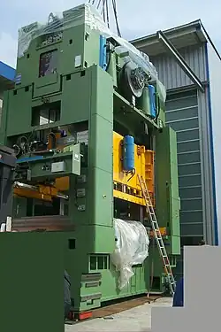 Bär (gelb) in der Hydraulikpresse