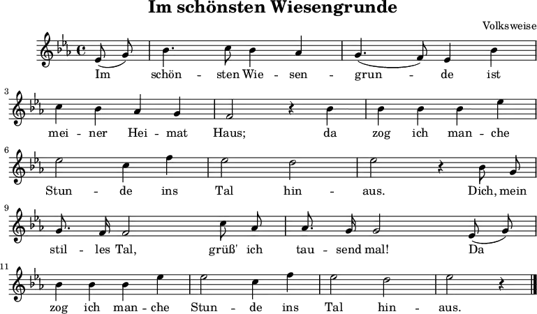 \language "deutsch"
\header {
title = "Im schönsten Wiesengrunde"
composer = "Volksweise"
tagline = ##f
}
\score {
<<
\chords {
}
\relative c' {
\key es \major
\time 4/4 \partial 4
\autoBeamOff
es8( g) b4. c8 b4 as g4. (f8) es4 b' \break
c b as g f2 r4 b b b b es \break
es2 c4 f es2 d es r4 b8 g \break
g8. f16 f2 c'8 as as8. g16 g2 es8( g) \break
b4 b b es es2 c4 f es2 d es r4 \bar "|."
}
\addlyrics {
Im schön -- sten Wie -- sen -- grun -- de ist mei -- ner Hei -- mat Haus;
da zog ich man -- che Stun -- de ins Tal hin -- aus. Dich, mein stil -- les Tal,
grüß' ich tau -- send mal! Da zog ich man -- che Stun -- de ins Tal hin -- aus.
}
>>
\layout { indent = 10\mm }
\midi {}
}