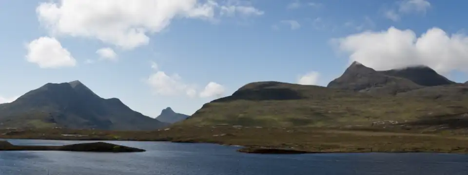 Blick über den Lochan an Ais nach Westen. Links der Meall Dearg und der Cùl Beag, in der Hintergrundslücke der Stac Pollaidh. Rechts dann der Bergstock des Cùl Mòrs mit An Laogh, Creag nan Calman und Hauptgipfel.
