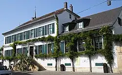 Blick von Nordosten auf das von einer Glyziniengirlande umschlungene Hauptgebäude