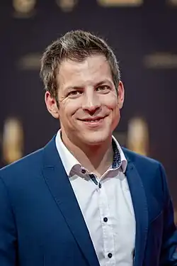 Daniel Schüler im dunkelblauen Sakko und weißem Hemd