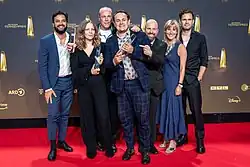 Gruppenfoto vor Senderlogo-Wand