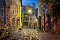 Gewundene Kopfsteinpflasterstraße, gesäumt von Fachwerkhäusern bei Nacht