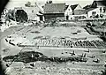 Nordwestlicher Lagerbereich während der Ausgrabungen 1942 mit den Balkenfundamenten der ältesten Umwehrung. Die aufrecht stehenden Hölzer im Vordergrund gehören einer späteren Phase an.