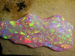 Brasilianischer Opal. Das Opalisieren entsteht durch Reflexion und Interferenz des Lichtes zwischen Kieselgelkügelchen (150 bis 400 nm).