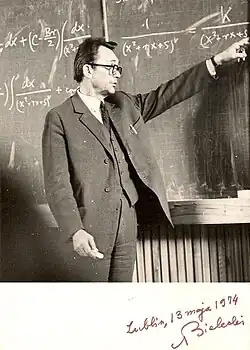 Prof. Adam Bielecki steht vor einer Tafel und zeigt darauf