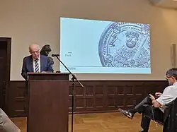 Redner links im Bild am Stehpult bei einem Symposium an der FSU in Jena,iThüringen.
