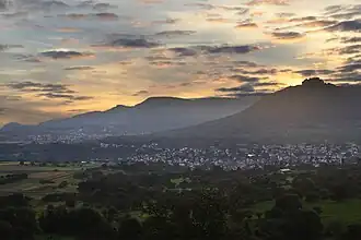 Albtrauf, Mittlere Schwäbische Alb, gesehen vom Osthang (575 m) des Jusibergs (672,6 m). Die Orte sind Neuffen und Beuren. Den Albtrauf bilden Hohenneuffen (745,4 m), Bassgeige (735,6 m), westlich von Beuren der Engelberg (527,2 m) und weiter hinten der Teckberg (774,8 m) mit vorgelagertem Schwäbischen Vulkan Hohenbol (602,2 m). Am Albtrauf liegt ausladender Hangschutt. Das Vorland mit den beiden Orten ruht auf Schichten des Braunen Jura.