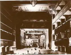 Blick aus dem Zuschauerraum in Richtung Bühne (um 1880). Rechts im Rang die Kaiserloge.