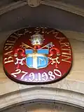 Das päpstliche Wappen über dem Hauptportal