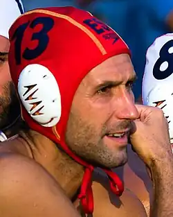 Andreo trägt eine rote Wasserballmütze mit der Kappennummer 13.