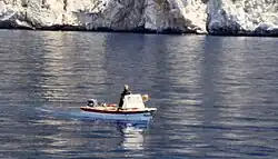 Mönch mit Motorboot und Mobiltelefon holt eine Proviant-Lieferung von einem Ausflugsschiff (2002)