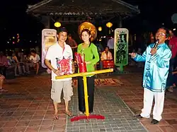 Die zwei Hieu mit Gewinner, das Gestell hält den Bambuscontainer mit den Spielstäben