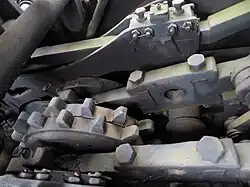 Einer der Kreuzköpfe des Innen­trieb­werks (im Bildhintergrund) treibt über eine Treibstange das zweite nicht sichtbare Triebzahnrad an. Vorne und mittig die beiden Rahmenwangen des sogenannten Zahnradwagens.