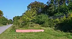 Links: Hausbahnsteig; roter Sims zeigt die Breite des Mittelbahnsteiges; rechts: Damm des Gleises von Borbeck