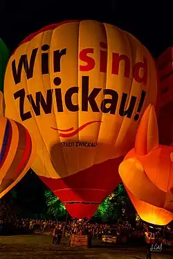 Heißluftballon mit der Aufschrift „Wir sind Zwickau!“, im Vordergrund rechts und links kleinere Ballons, im Hintergrund viele Menschen.