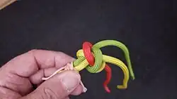 Mit dem roten und gelben Kardeel wird ebenso verfahren, bis die Kardeele mittig aus dem Strang kommen.