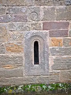 Romanisches Fenster und Kopfrelief am Turm