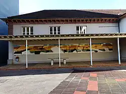 Bemaltes Holzrelief, (Querschnitt durch die Tektonik einer Juralandschaft), 1976. Von Konrad Hofer (1928–2006) Maler, Bildhauer. Pestalozzischule, St. Johannplatz 9