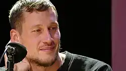 Benedikt Feiten in Nahaufnahme, er blickt leicht seitlich in die Kamera.