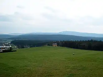 Blick vom Bärenstein auf den Höhenzug Stahlberg mit Toskabank und Feuerturm. Im Hintergrund Fichtelberg (rechts) und Klínovec (Keilberg) (links).