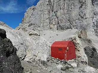 Die Biwakhütte Marco Dal Bianco (2015) im Hintergrund der Passo Ombretta, die Südwand der Marmolata und am linken Bildrand die Forcella Marmolada (2885 m)