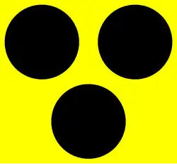 Drei schwarze Punkte auf gelbem Grund