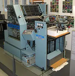 Eine Einfarben-Bogen­offset-Druckmaschine, Typ „Roland Favorit“, (1980). Deutlich zu er­kennen: der am Bogen­ende befindliche Schuppenanleger.