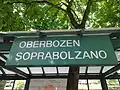 Zweisprachiges Bahnhofsschild, anders als bei der Staatsbahn hat bei der Rittner Bahn die deutsche Sprache Vorrang
