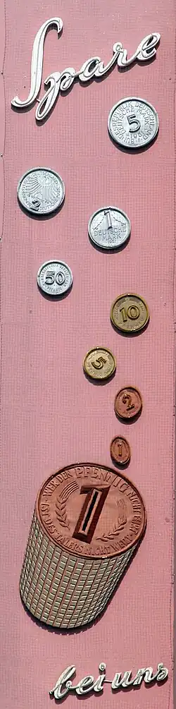 In der Zeit des Wirtschaftswunders konstruierte, in den 1950er Jahren am Bohlweg montierte und inzwischen denkmalgeschützte „Spare bei uns“-Leuchtreklame eines Geldinstituts, mit Abbildung aller Münzen damals neuer Währung.