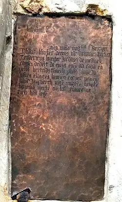 Der Grundstein von 1499 mit halbplastisch aus dem Stein herausgearbeiteter Statue der Maria Magdalena und einer eingelassenen Kupferplatte mit Informationen zu den Stiftern.