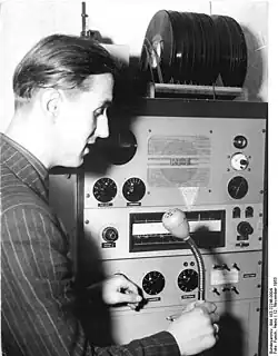 Pritzwalk, Koordinierungszentrale der MTS, 12.11.1953: Der Dispatcher fordert den Meister der Reparaturwerkstatt auf, den Reparaturwagen mit den benötigten Pflugscharen nach Bullendorf zu schicken, wo die Brigade „XIX. Parteitag“ auf dem Feld wartet.