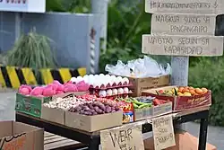 Foto eines kleinen Marktstandes mit Eiern, Äpfeln und verschiedenem Gemüse darauf
