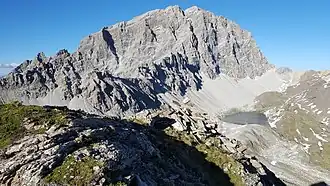 Steinmann auf dem Piz Furnatsch, im Hintergrund der Piz Ela.