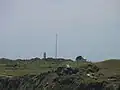 Gebiet des Cape Foulwind Lighthouse mit neuem Turm, Antennenmast und Hügel des alten Leuchtturmes