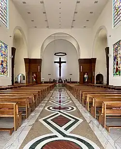 Innenaufnahme der Herz-Jesu-Kathedrale in Colatina, die hier mit den hellbraunen Kirchenbänken und weiß getünchten Hauptschiff fast schlicht anmutet, jedoch noch weitere Buntglasfenster und Zierart aufweist