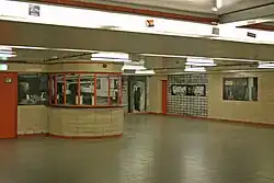 Geschlossener Fahrkartenschalter im nördlichen Verteilergeschoss, 2024. Hinten rechts befand sich hinter der orangefarbenen Tür bzw. der Wand mit der Aufschrift „Stettiner Bahnhof“ der Verbindungstunnel zum Fernbahnhof.