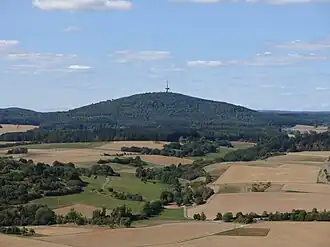 Blick vom Bergfried der Burg Gleiberg nach Nordwesten zum Dünsberg, rechts neben dem Windrad im Hintergrund der Fernseh-Sender-Turm Angelburg
