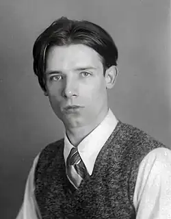 Werner Heldt auf einer Schwarz-Weiß-Fotografie im Viertelprofil. Er trägt ein weißes Hemd, einen marmorierten Pollunder und eine Krawatte. Die Haare sind in der Mitte gescheitelt, die Augen hell, das Kinn hat ein Grübchen.