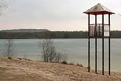 Altwarmbüchener See mit Badestrand, dahinter der Nordberg der Deponie Hannover-Lahe