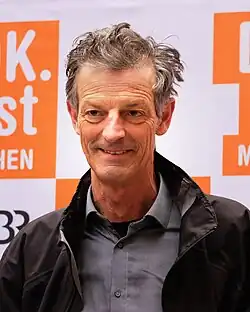 Daniel Sponsel vor Fotowand mit DOK.fest-Logos