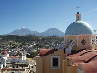Blick vom Turm der Pfarrkirche San Andrés Apóstol über die Stadt; im Hintergrund die Berge Sierra Negra (rechts) und Pico de Orizaba (links)