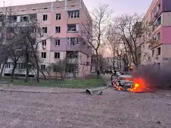 Brennende und zerstörte Zivilfahrzeuge und Gebäude im angegriffenen Wohnviertel