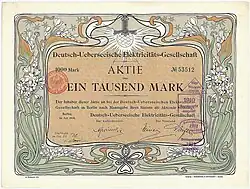 Aktie der Deutsch-Ueberseeischen Elektricitäts-Gesellschaft (Compañía Alemana Transatlántica de Electricidad) über 1.000 Mark, ausgestellt in Berlin im Juli 1906. Mit Faksimileunterschrift Arthur von Gwinner (Vorstand Deutsche Bank) als Aufsichtsratsvorsitzender. Die graphische Gestaltung der Aktie stammt von dem Jugendstil-Künstler Otto Eckmann. Zweck der von der AEG gegründeten Gesellschaft war die Errichtung von Elektrizitätswerken vor allem in Südamerika (Buenos Aires, Santiago de Chile, Valparaiso, Montevideo). Die mit Abstand wichtigste Aktivität wurde später die Stromversorgung der argentinischen Hauptstadt Buenos Aires.