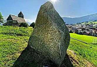 Menhir im Parc la Mutta, im Hintergrund die St. Remigius