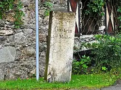 Zum Kilometerstein umgestalteter Meilenstein in Dorfgastein (Österreich)