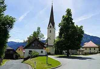Der Dorfplatz von Sankt Stefan im Gailtal mit der Pfarrkirche St. Stefan