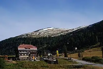 Dr.-Josef-Mehrl-Hütte von Süden, im Hintergrund der Klölingnock (2178 m ü. A.)